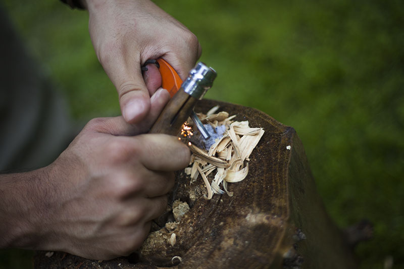 generating sparks with fire starter steel and opinel